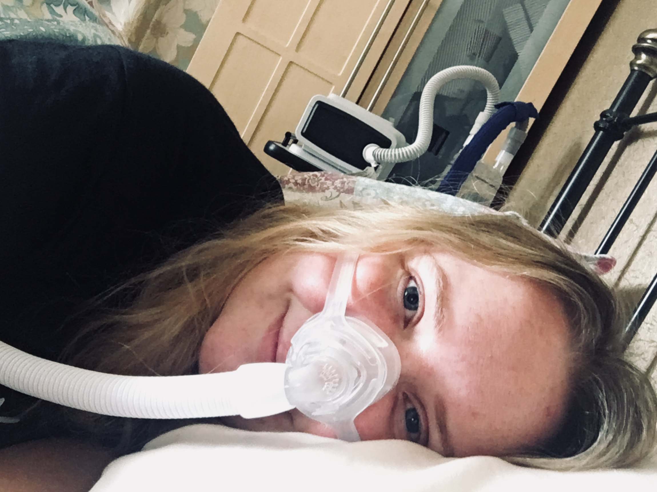 Laura Beattie smiling, wearing an oxygen mask