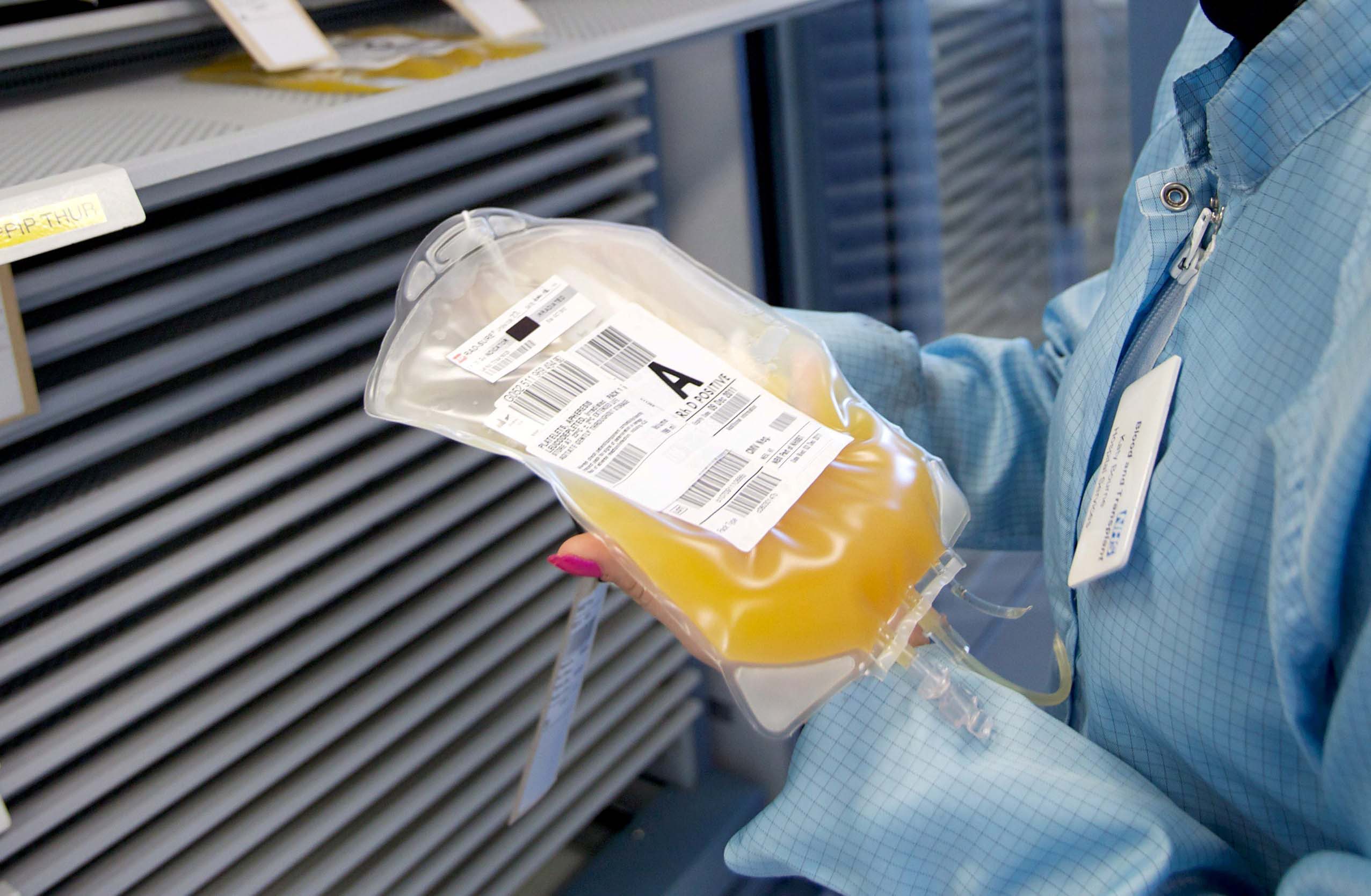 A person in a laboratory holds a bag of platelets