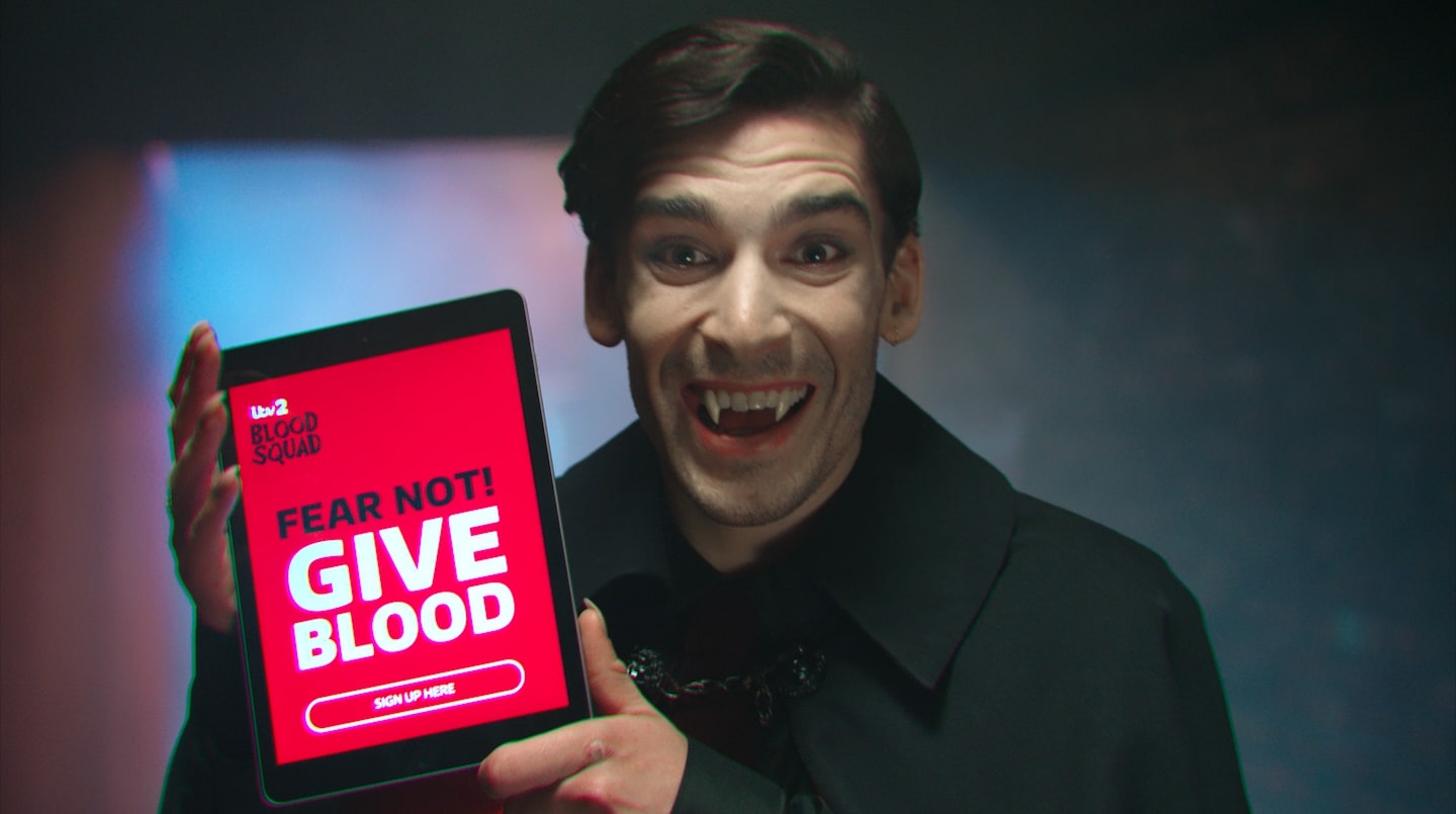 A vampire holds a computer tablet