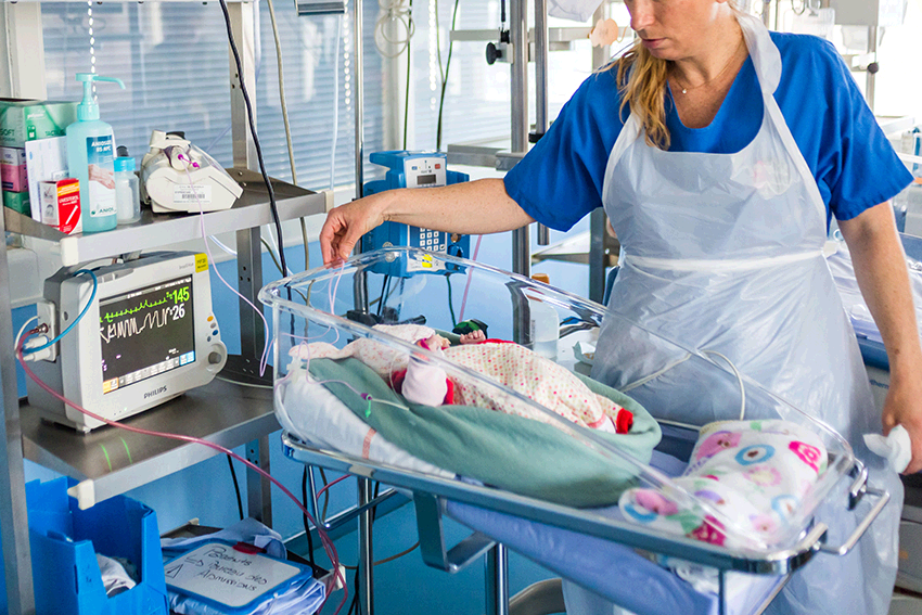 A newborn baby is cared for by a nurse