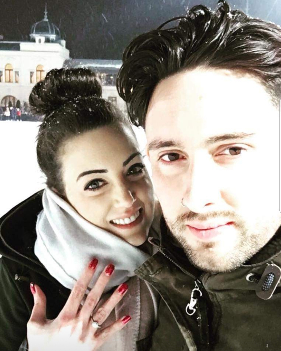 Emily poses with her engagement ring alongside Sam in the snow in Budapest