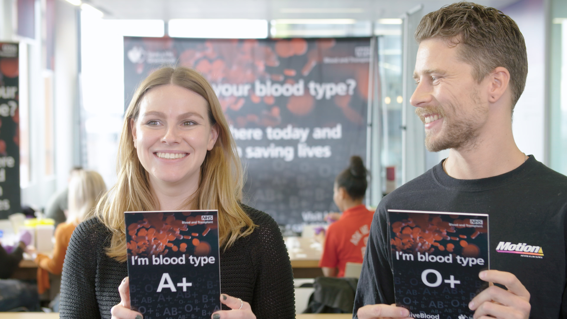 Two young people hold cards with their blood type on