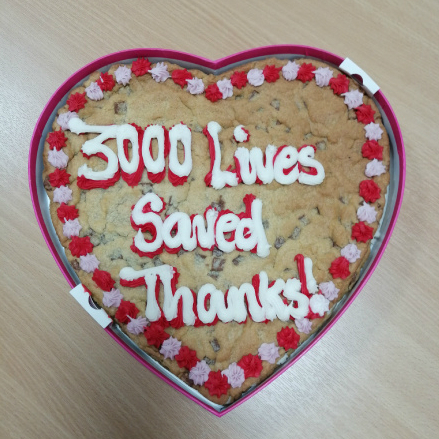 A large, heart-shaped cookie with icing that reads, '3,000 lives saved. Thanks!'