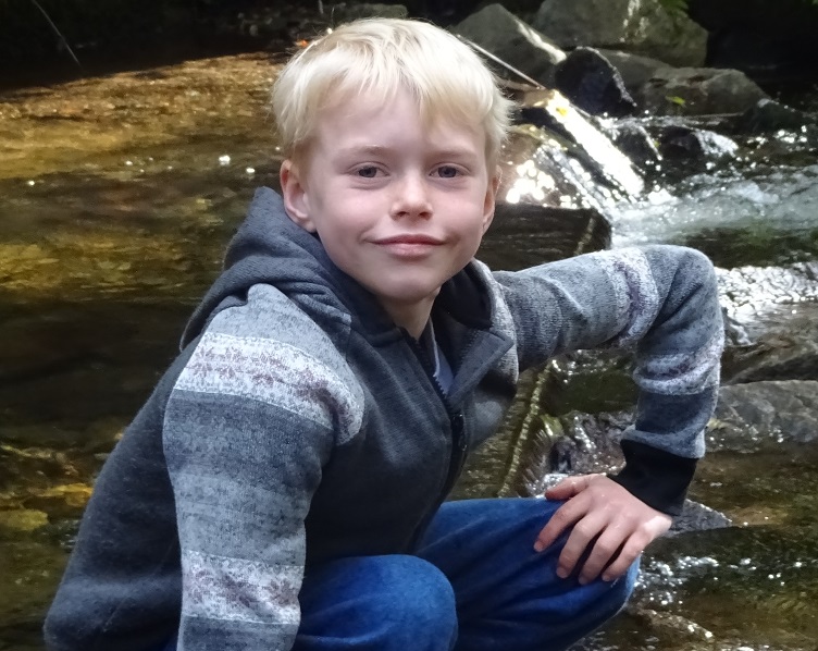 Max pictured next to a stream, smiling