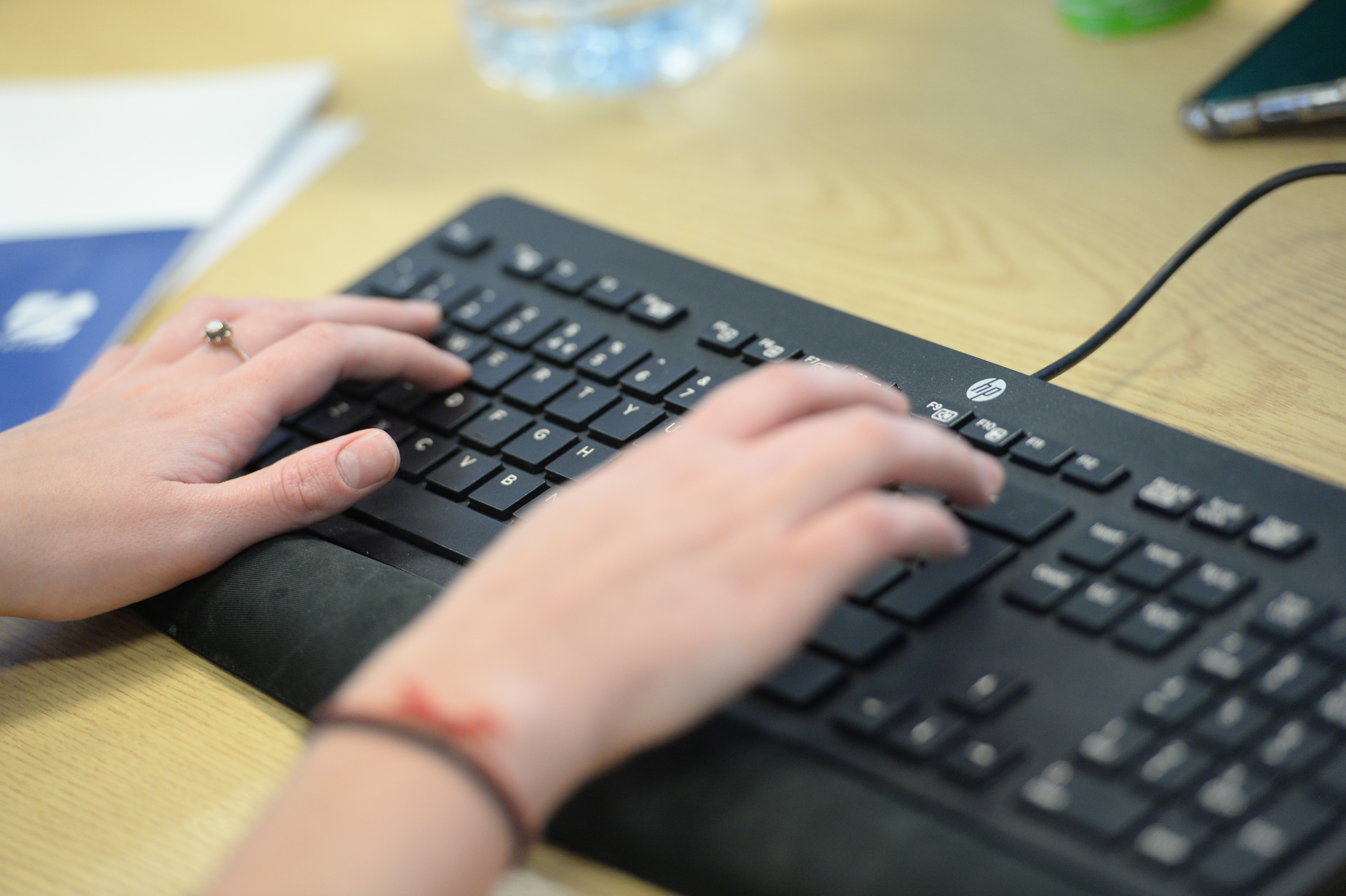 Member of staff typing on a keyboard