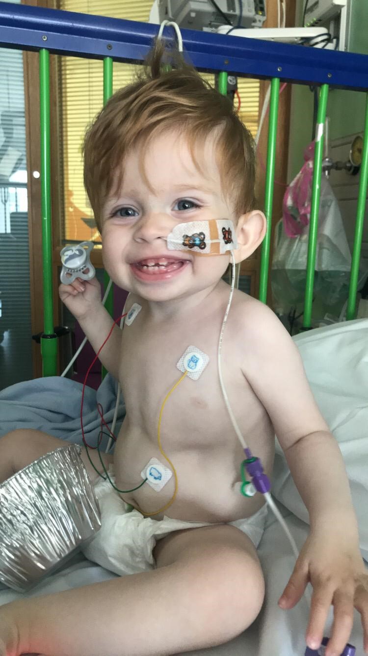 Grayson in a hospital cot with tubes and wires on his nose and chest