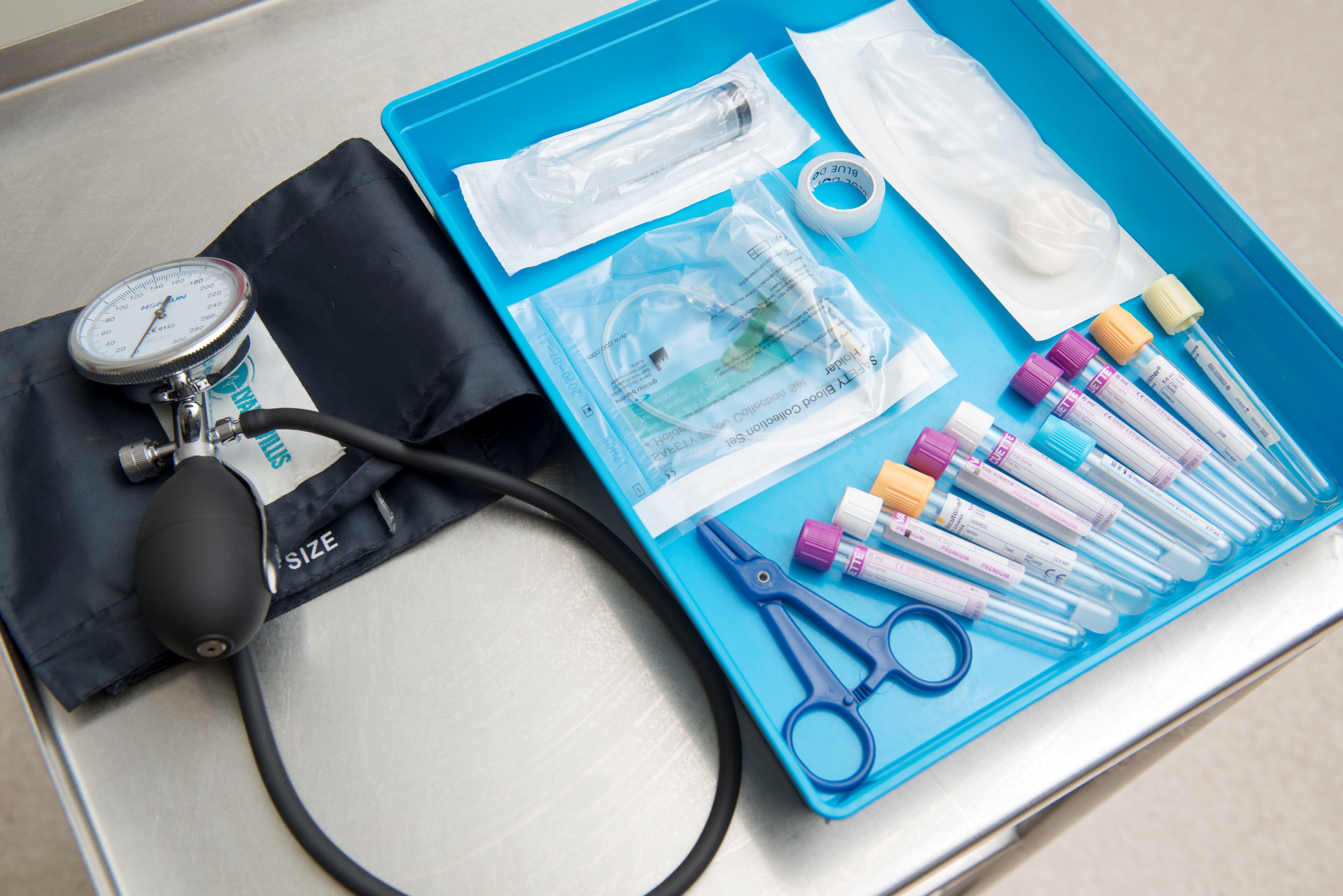A tray of medical equipment including vials, scissors and a stethoscope