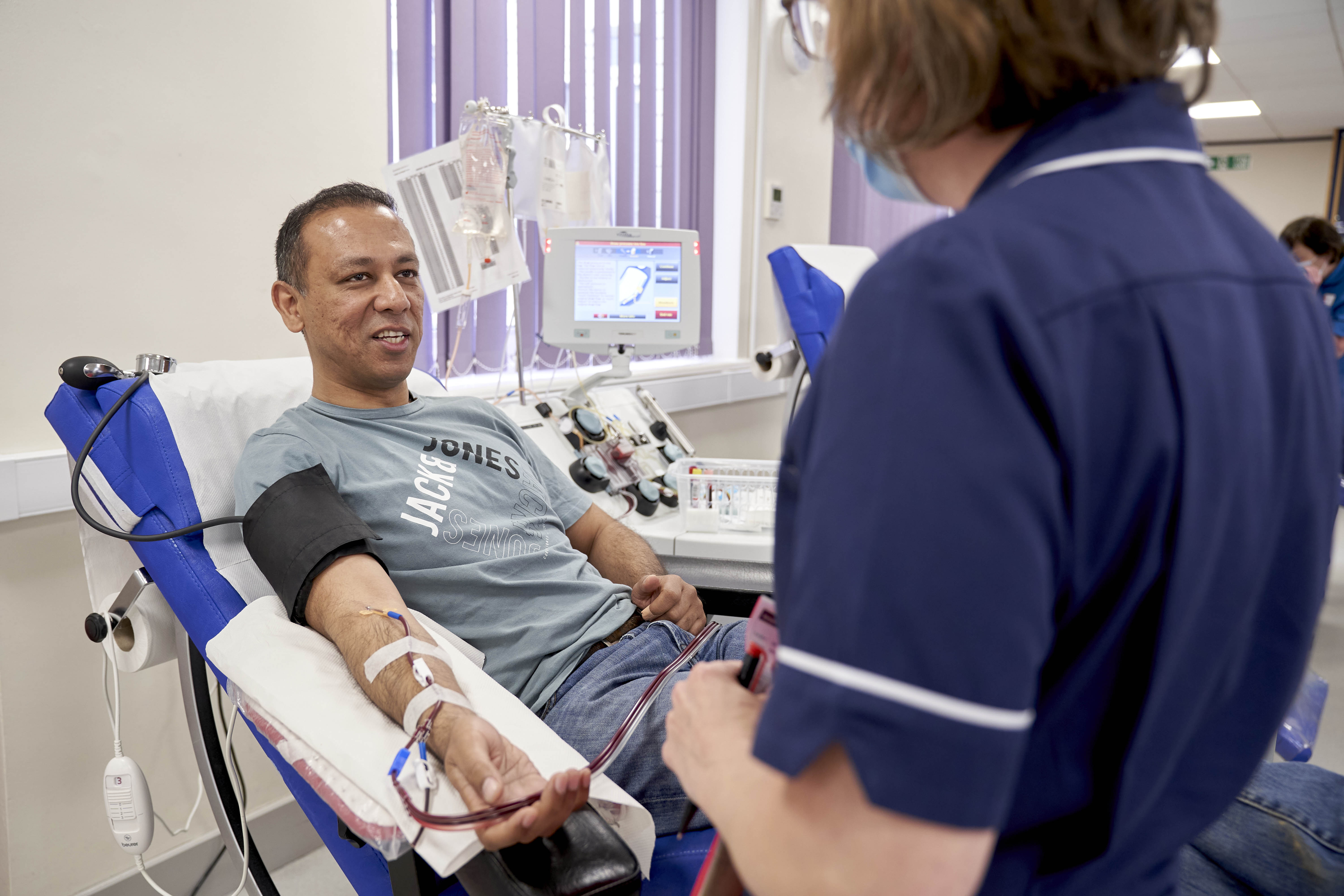 Dt Abhi Lal speaks to a donor carer while he donates plasma