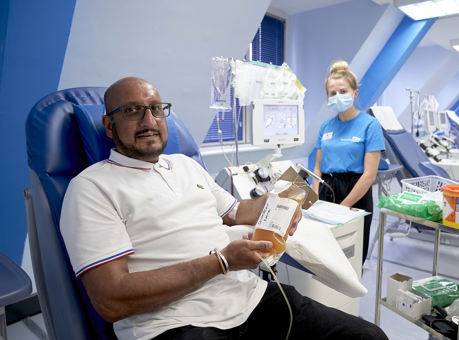 A donors holds a bag of his plasma