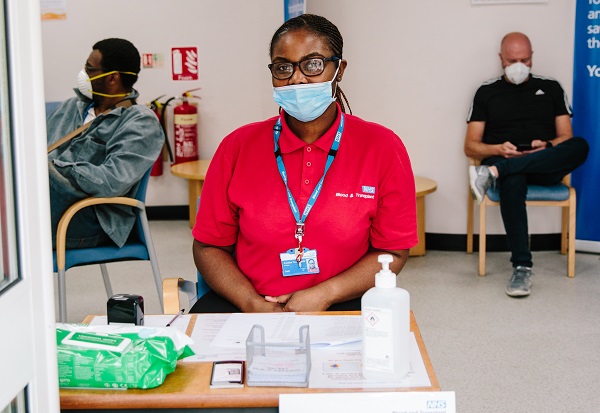A donor carer sits at a table, ready to triage blood donors