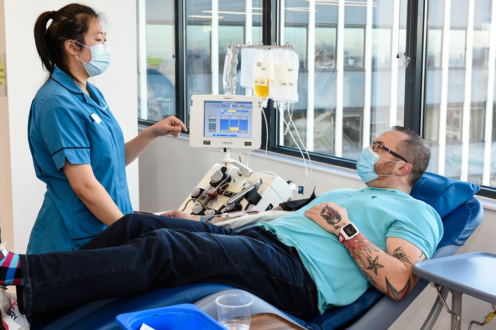 A man lies back in a chair while he donates plasma