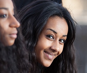 Black teenage girl leaning forward and smiling