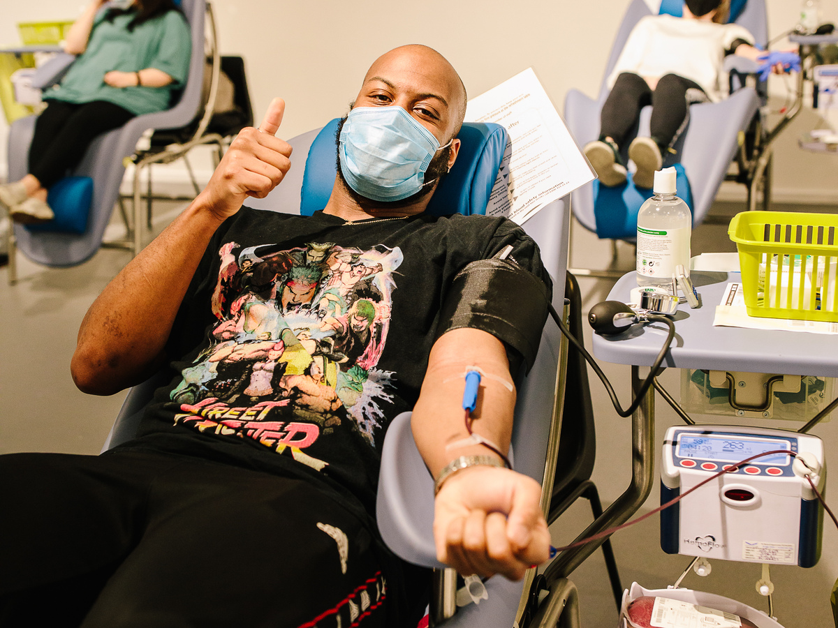 Black man donating blood giving thumbs up