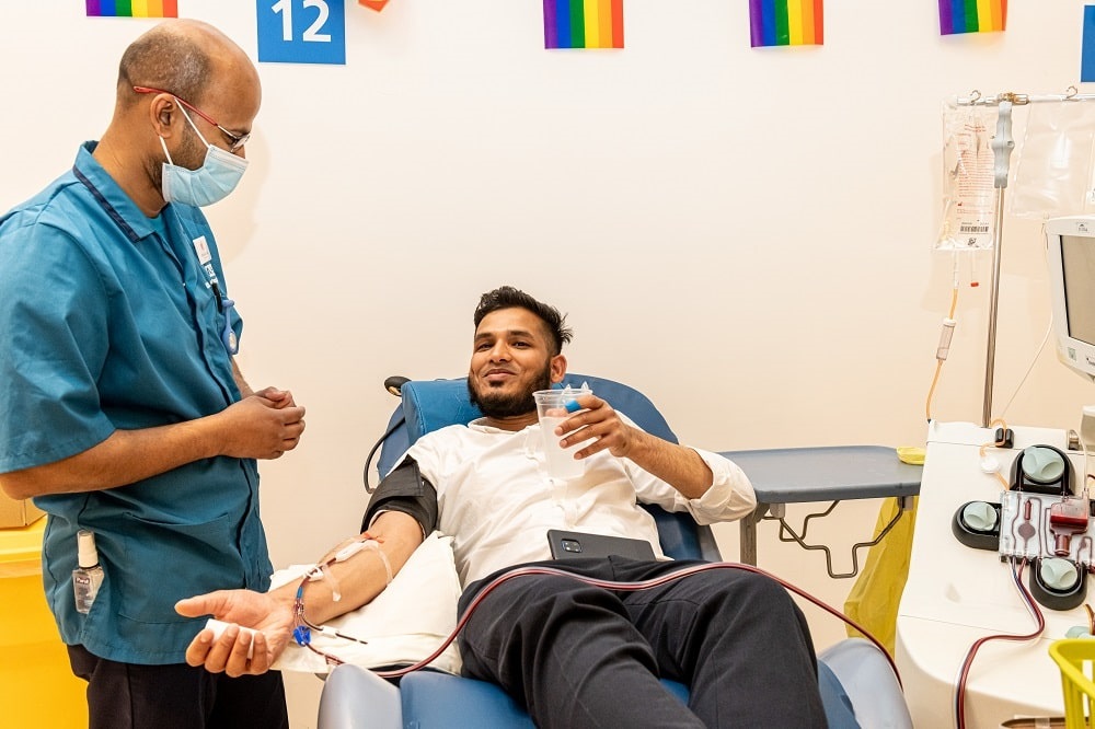 A man chats to a donor carer while he donates plasma