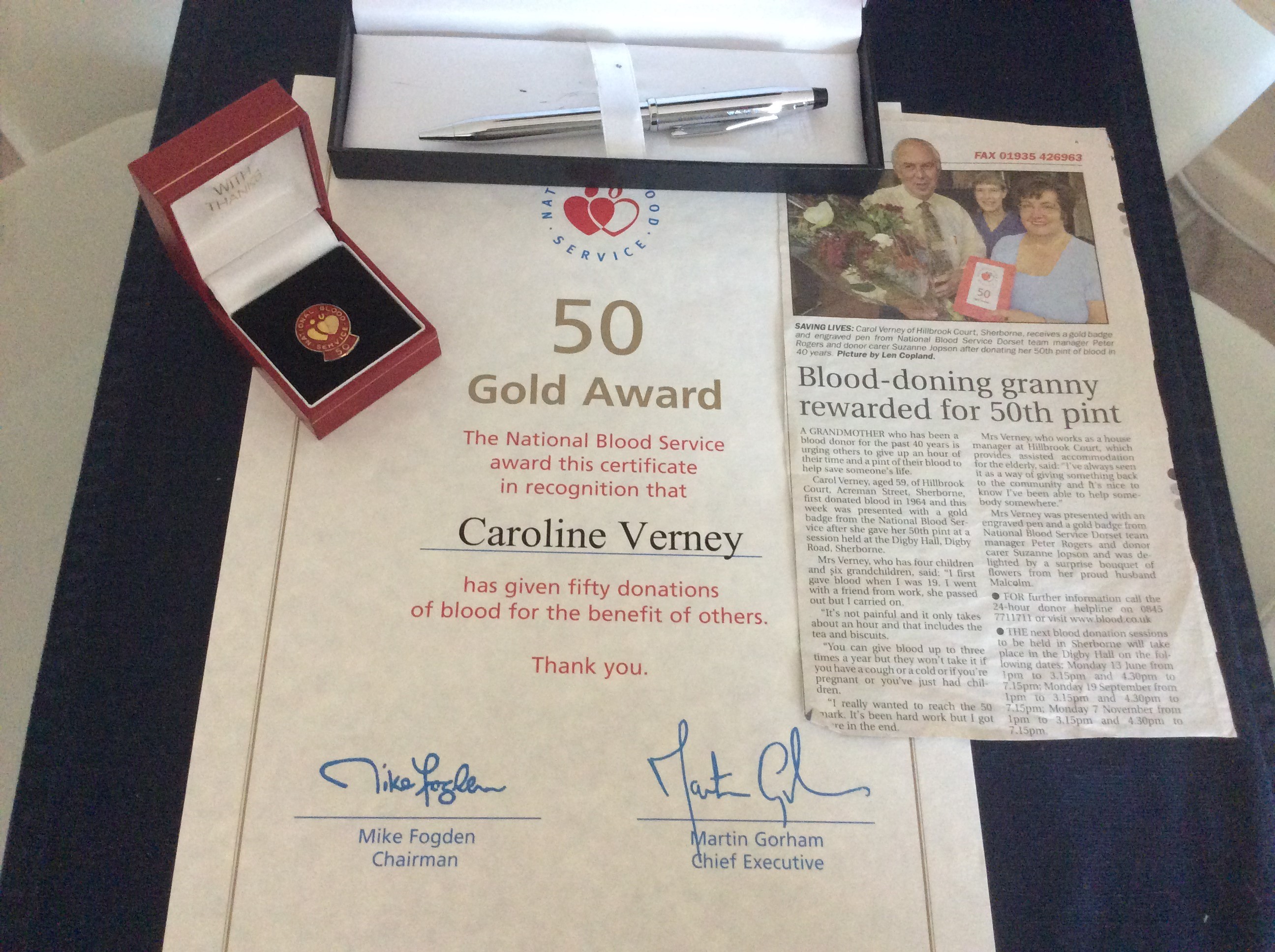 Carol's 50th donation certificate, badge and newspaper article