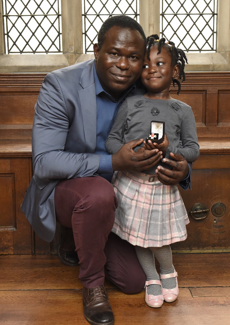 Oluwaseun and McKayle holding their Order of St John award at a London ceremony in 2015