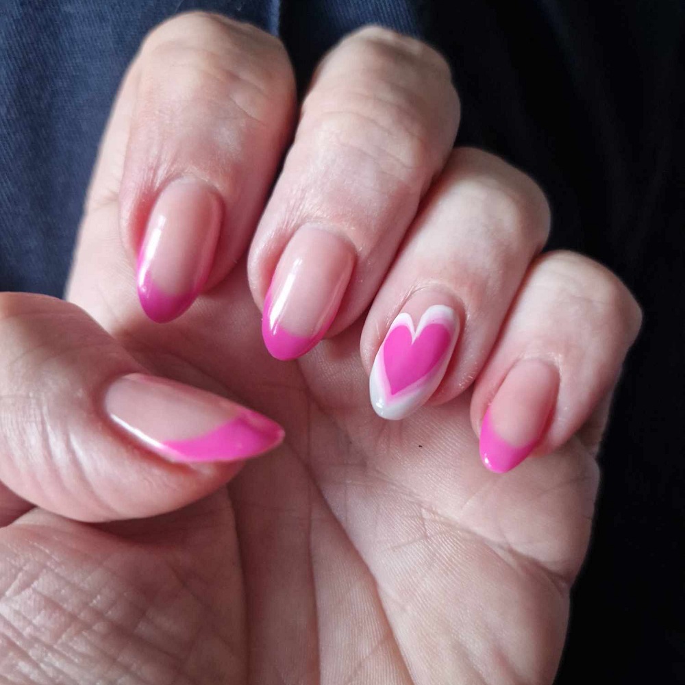 An image of Organ Donation Week themed nails - pink tipped nails with hearts painted on