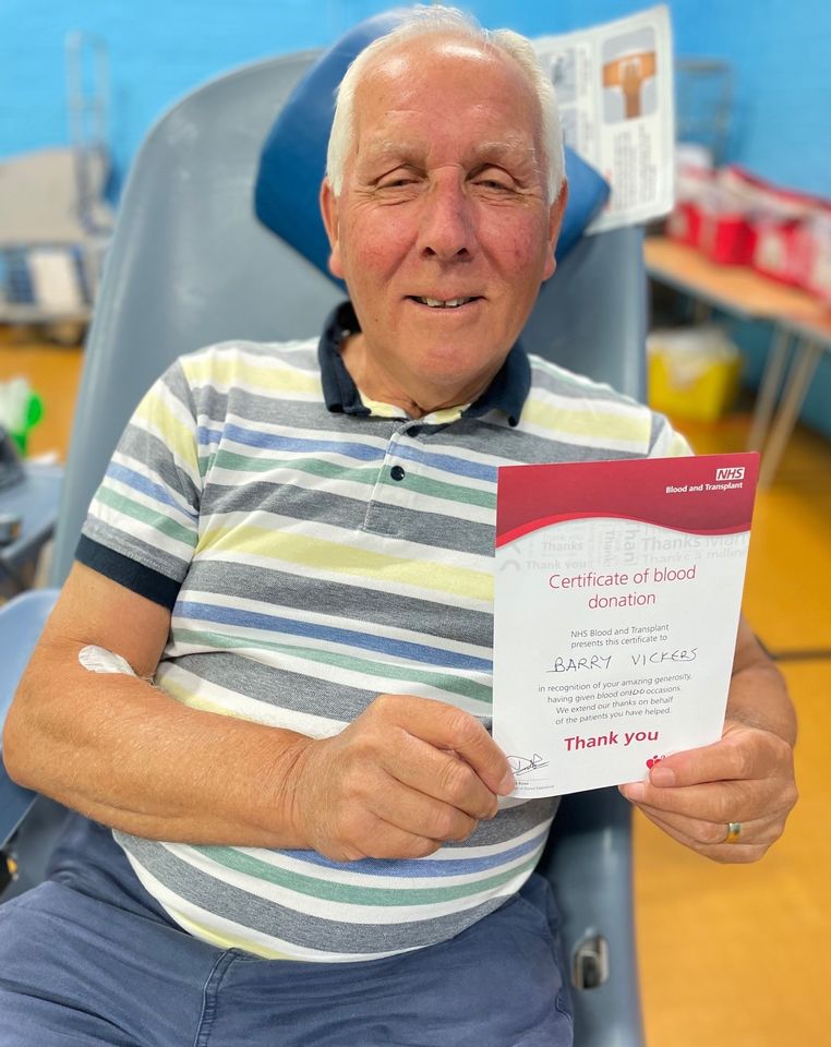 Barry holding a donation certificate