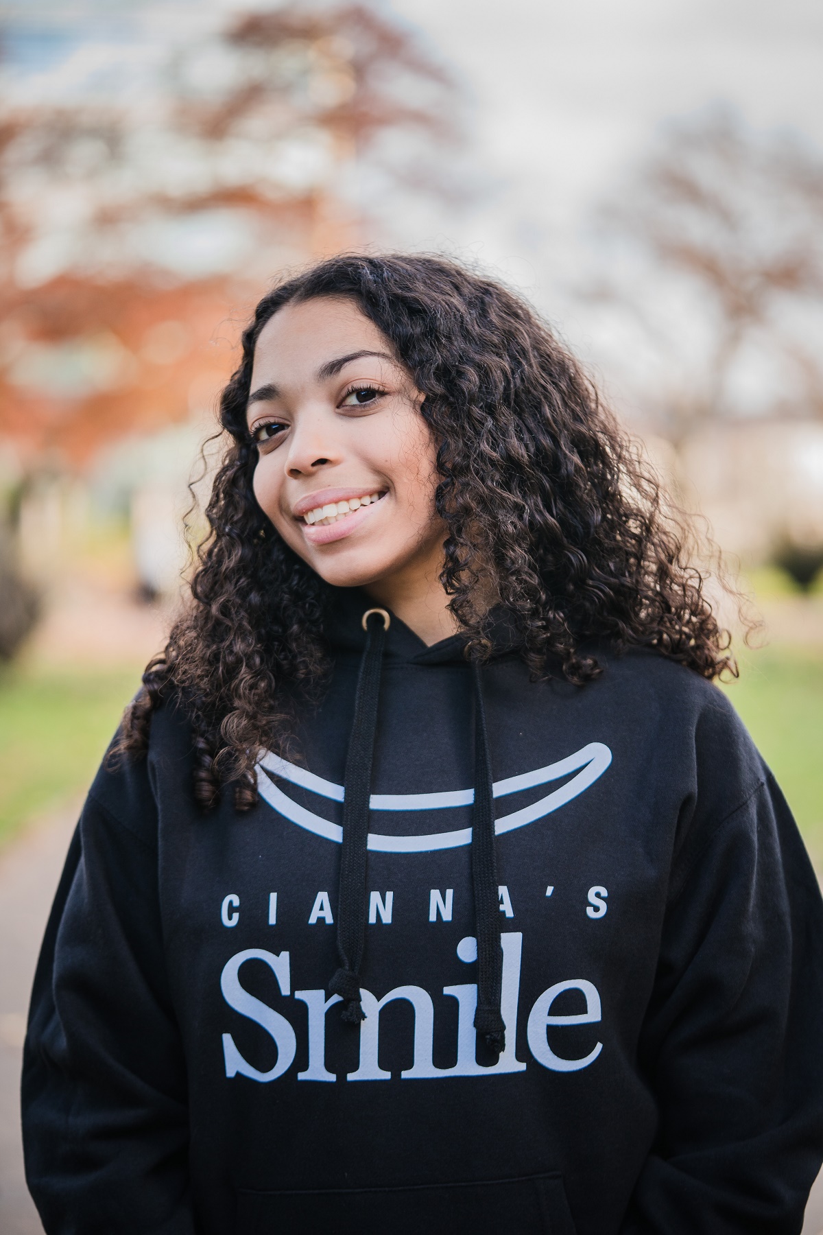 Cianna smiling in a hoodie that says "Cianna's Smile"