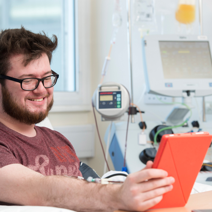 Stem cell donor donating whilst reading an electronic device