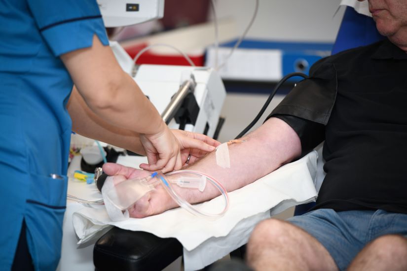 Donor carer removing the needle from a donor's arm