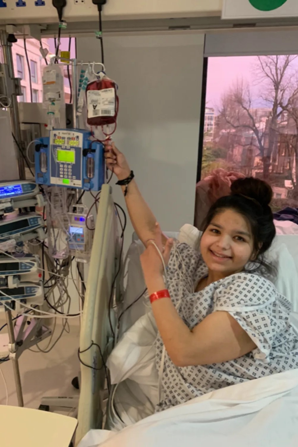 Shilpa holds up a blood bag before a transfusion