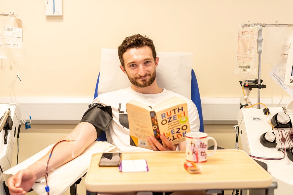 Platelets donor reading a book while donating