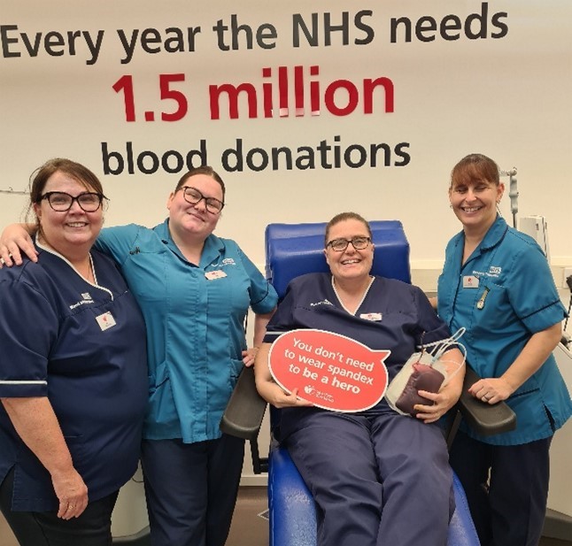 Emma sitting after her 73rd blood donation with her colleagues