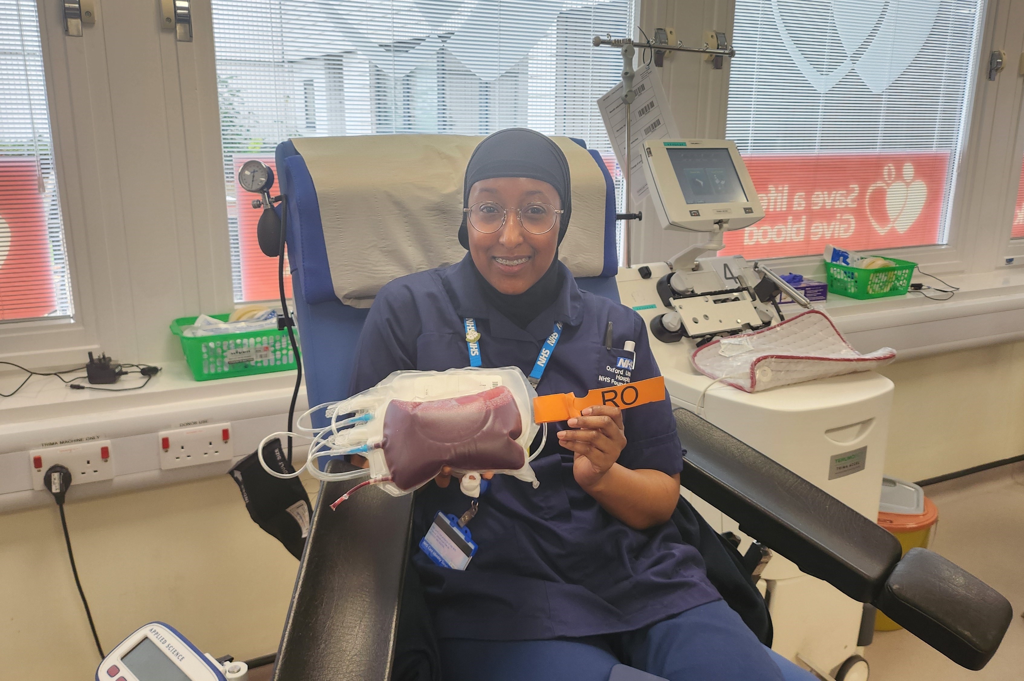 Amino holding the bag of Ro blood which she has donated