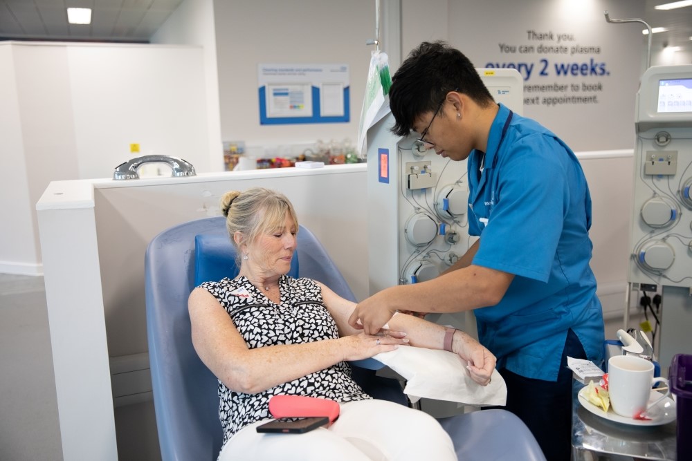 A donor carer with a donor giving plasma