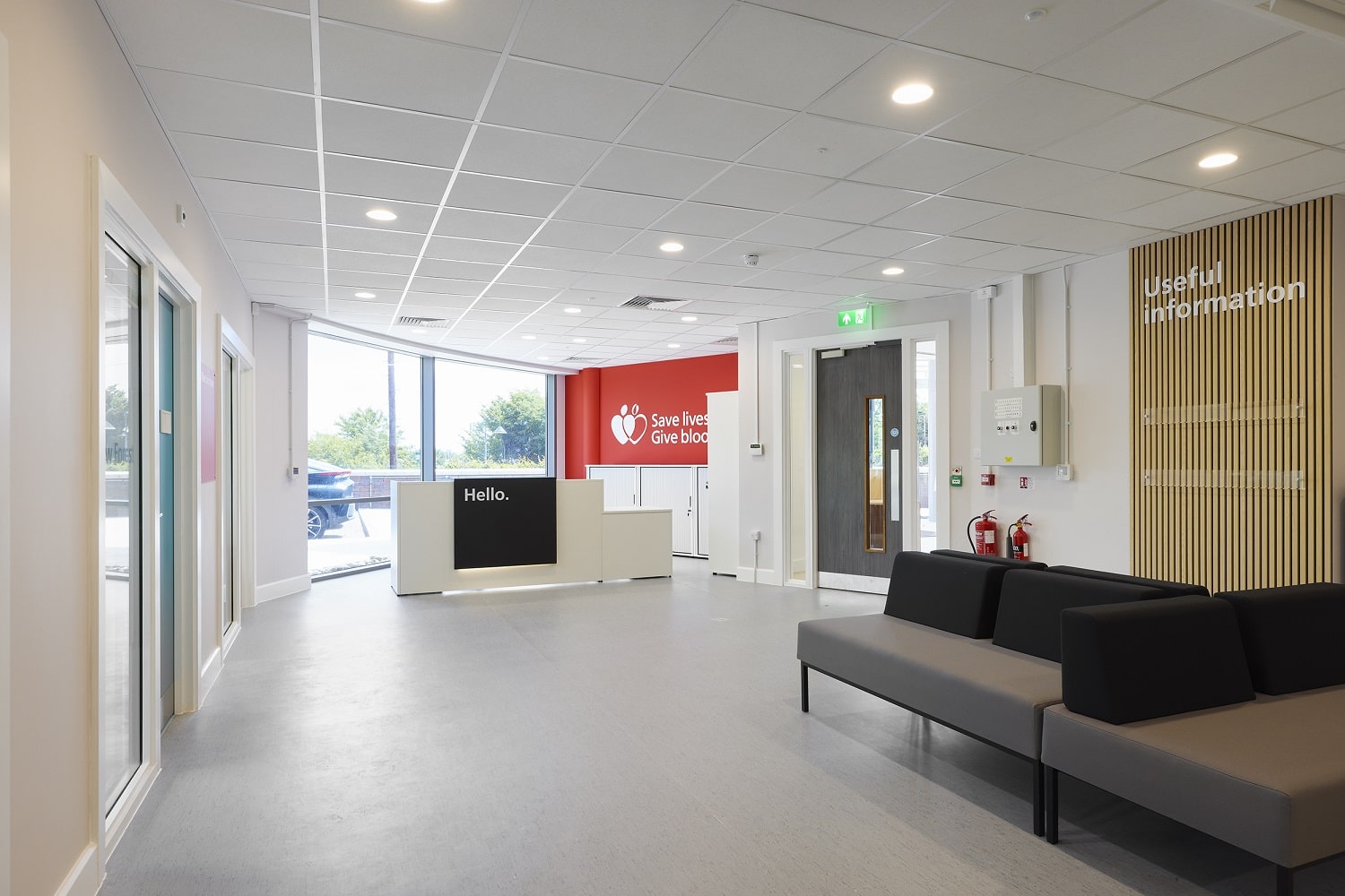 Reception area of Southampton Donor Centre, a reception desk with the word "Hello" written in large letters greets donors as they enter, there are comfortable sofas for donors to use while they wait