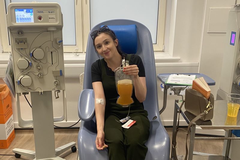 Emma Greenwood holds up her plasma donation