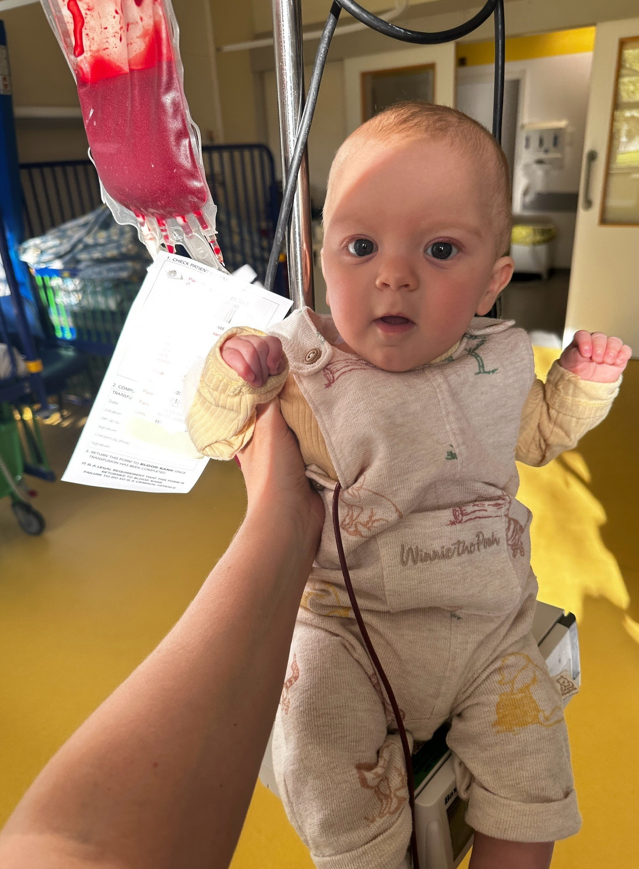 Woody as a baby, being held up as he gets a blood transfusion