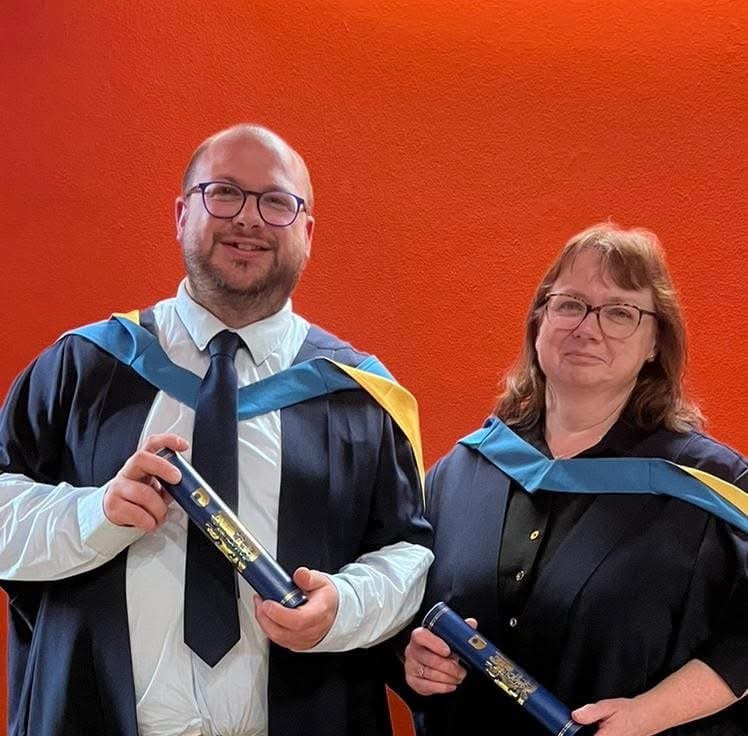 Ben (left) and Pam (right), Ben's mum, both in graduation gowns standing side by side