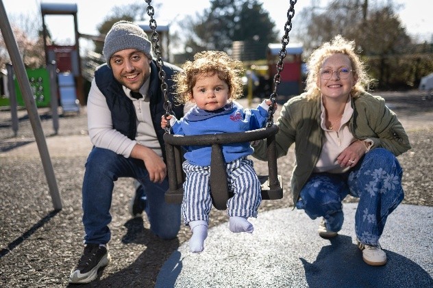 Jess (pictured on the right), with husband Jacob (on the left) with son Ezra on a swing between them