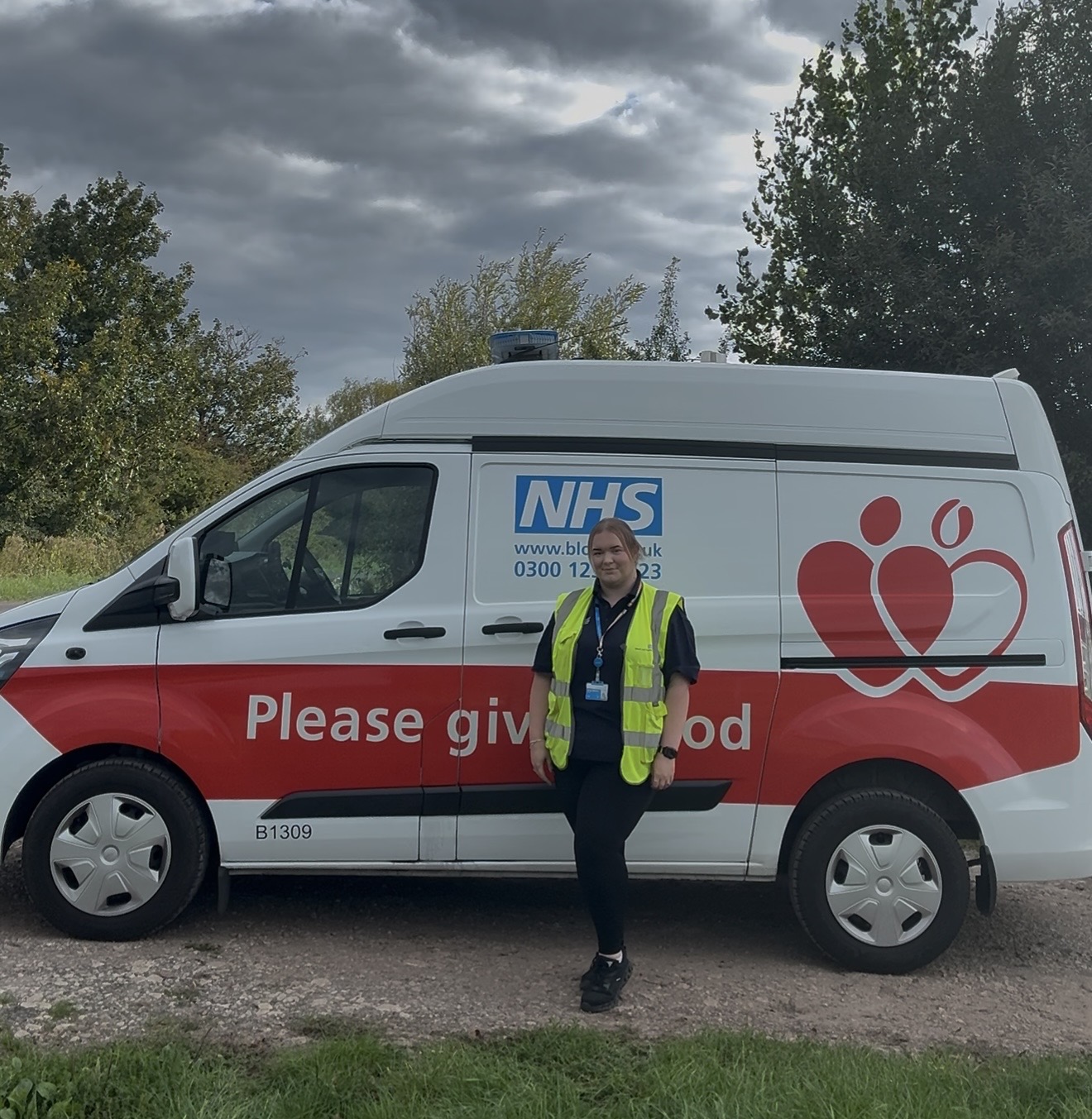 Emily standing in front of a blood delivery van