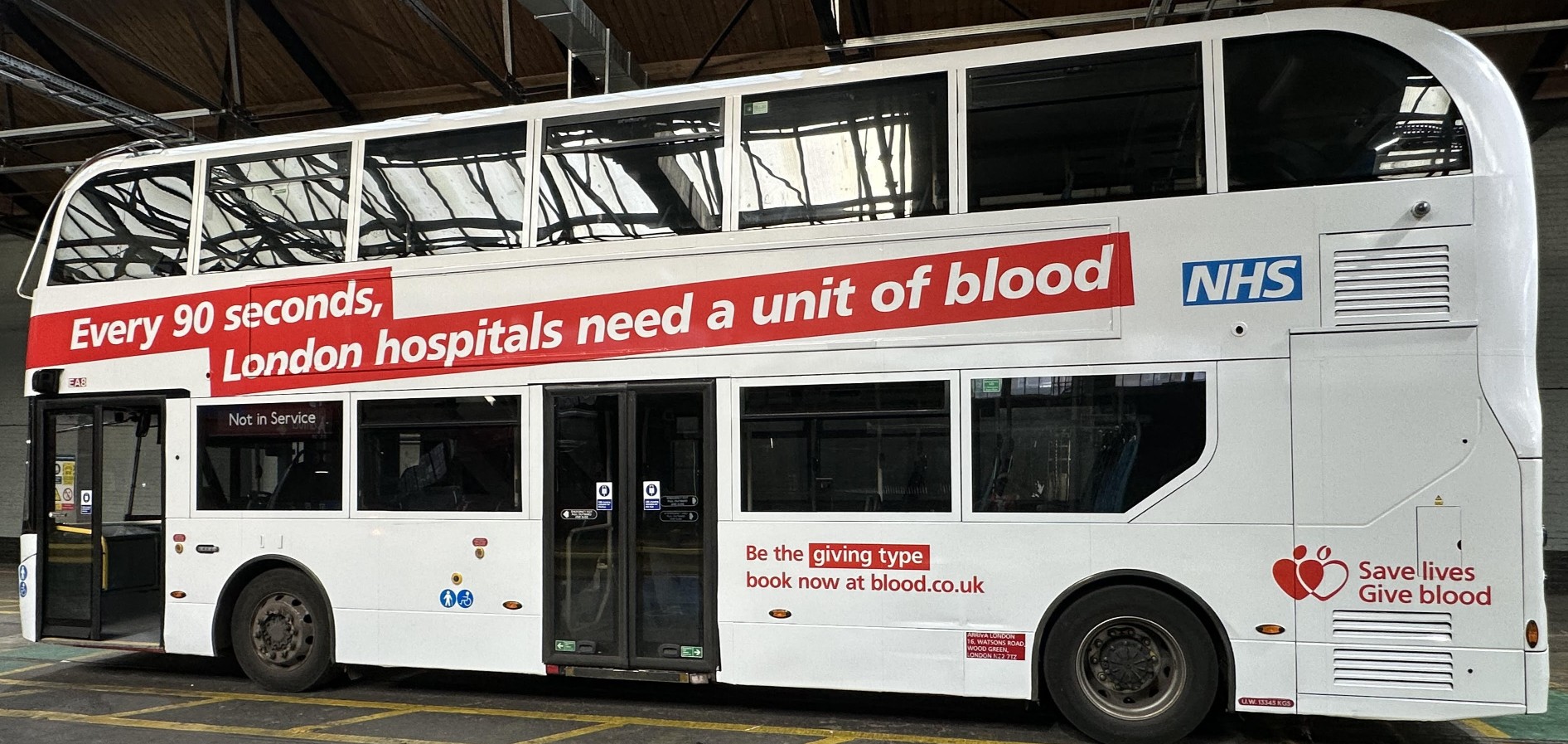 A side on view of the specially wrapped double decker bus, with the words "Every 90 seconds, London hospitals need a unit of blood"