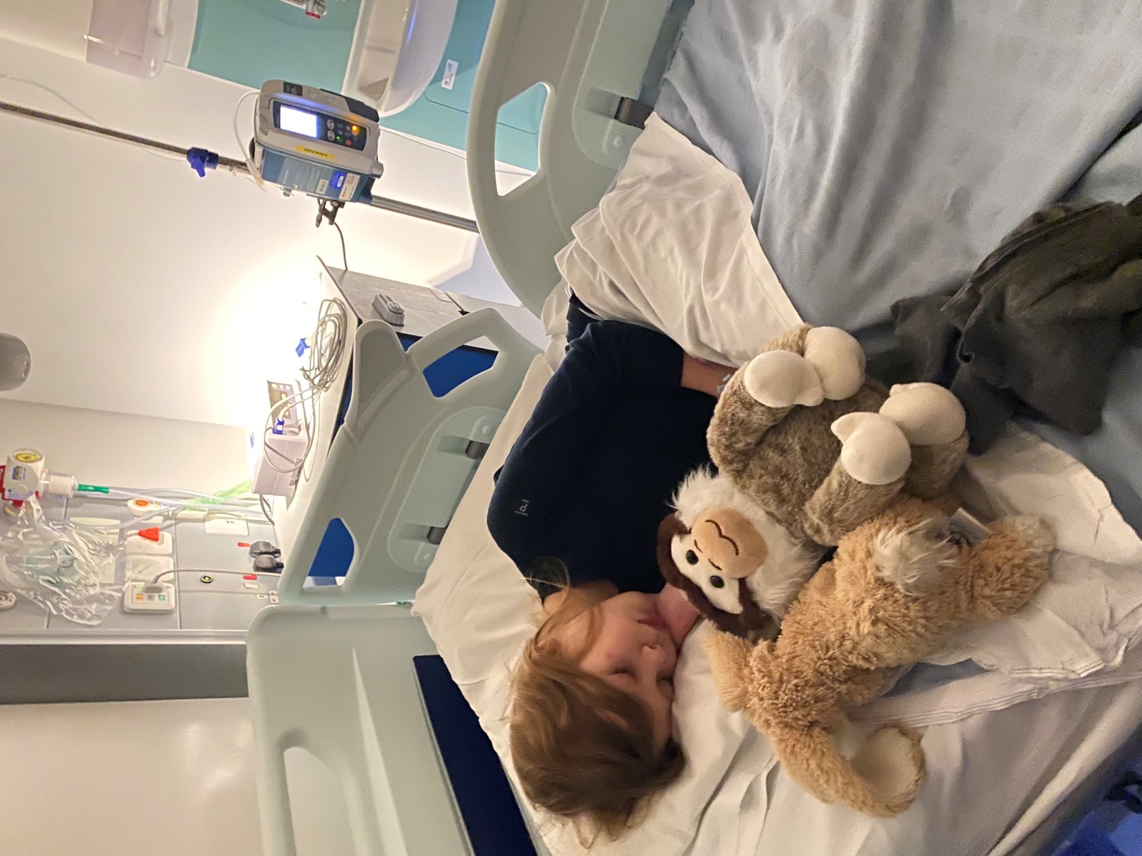 Winifred lying in a hospital bed, receiving intravenous immunoglobulin therapy