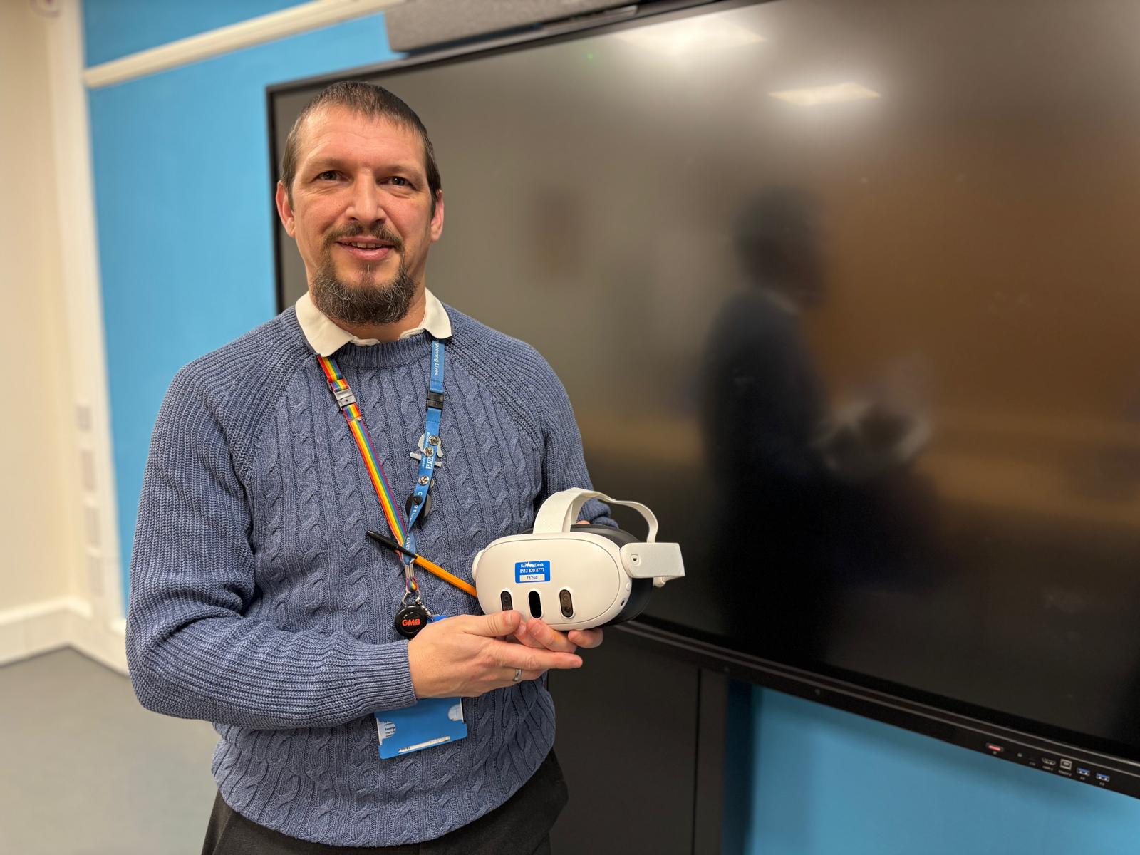 Matt Noad, Senior Retrieval Assistant, holding a VR headset at a demo of the new VR training programme