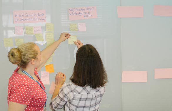 NHSBT staff arrange post-it notes during a planning meeting